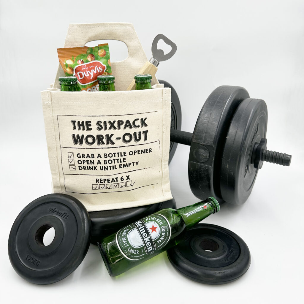 Sixpack Work-Out geschenkpakket met Heineken bier, notenzakje en bottle opener tussen halterschijven