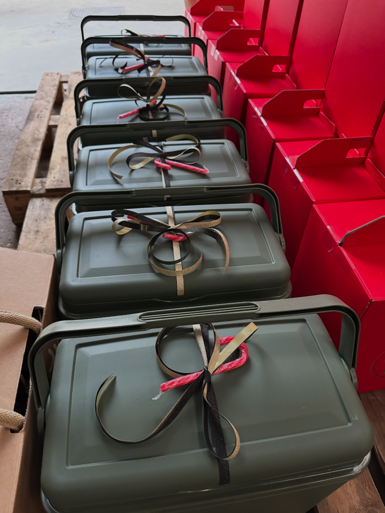 Rij groene koelboxen versierd met strik, rode koelboxen op de achtergrond