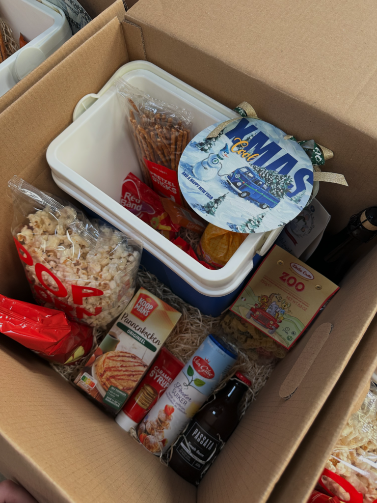 Kerstpakket in doos gevuld met chips, koekjes en andere lekkernijen